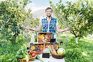 handsome farmer standing with open arms near stall