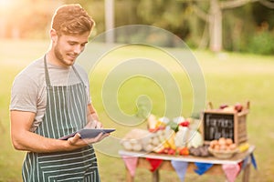 Handsome farmer using his tablet