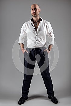 Handsome Fashion Man in White Shirt. Bearded Brutal Men over dark Gray Background. Elegant Bald Head Unshaved Male Model