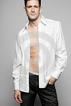 Handsome fashion model posing in white shirt.