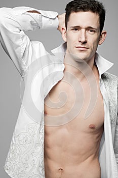 Handsome fashion model posing in white shirt.