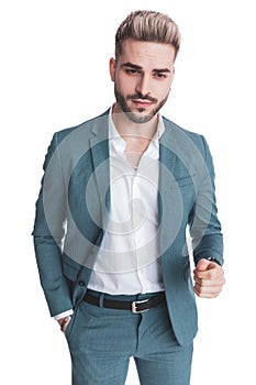 Handsome fashion model in suit with untied shirt holding hand in pocket