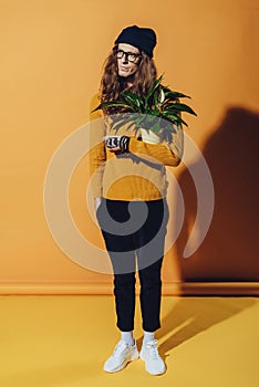 handsome fashionable man posing with green plant photo