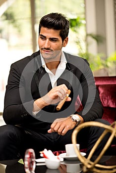 Handsome fashionable man Smoking Cigar in a Business Lounge