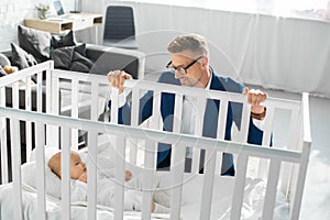 handsome father in formal wear sitting near infant daughter