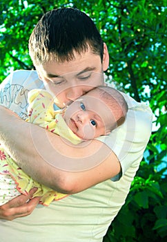 Handsome father kissing little baby