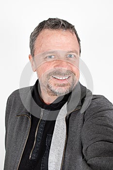 Handsome fifty year old mature middle age man make cell phone selfie picture on white background