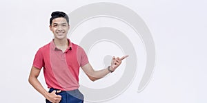 A handsome Filipino man points to the right endorsing a product or service. Copy space on the right. Isolated on a white photo