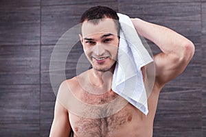 Handsome fit guy is drying himself after bathing