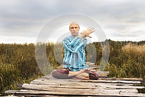 Handsome fit man doing yoga at the park