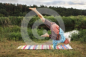 Handsome fit man doing yoga at the park