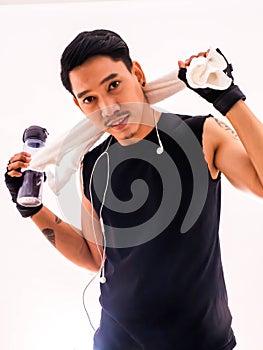 Handsome fit man holding a towel and a bottle of water with happy fitness