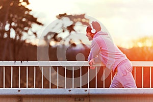 Man runner taking a break after intensive training outdoors, listening music on his mobile smart phone