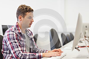 Handsome focused student working in computer room