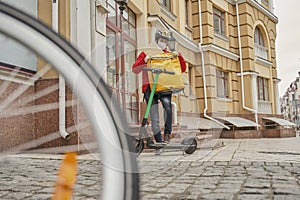 Handsome food delivery courier pulls out an order while standing