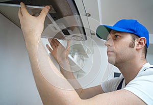 Handsome foreman fixing exhaust hood.