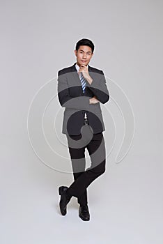 Handsome and friendly face asian businessman smile in formal suit and interested in thinking isolated on white background