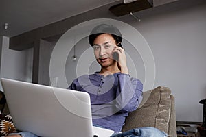 Handsome gay Asian Man using laptop and mobile phone
