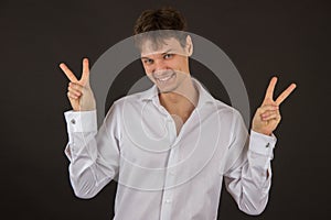 Handsome gay guy smiling in a shirt on a black background