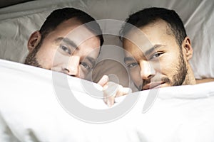 A Handsome gay men couple on bed together under the cover