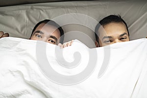 A Handsome gay men couple on bed together under the cover