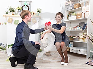 Handsome gentleman presents heart to his beautiful lady on white