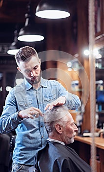 Handsome good looking barber cutting hair