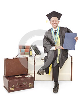 handsome graduated student sitting and holding certificate
