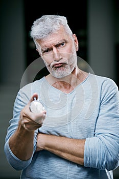 Handsome gray haired senior man with stopwatch in his hand. Sport and health care concept