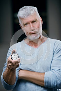 Handsome gray haired senior man with stopwatch in his hand. Sport and health care concept