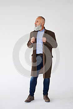 Handsome grey bearded man dressed in autumn coat