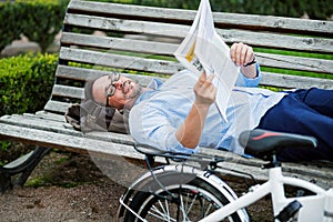 Handsome grizzled man reading newspaper.