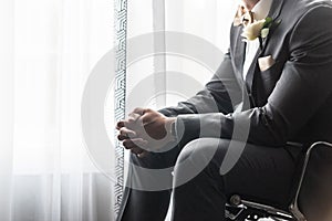 Handsome groom in a black suit praying before the wedding ceremony