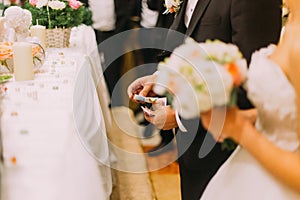 Handsome groom holding redemption of bride on wedding indoors