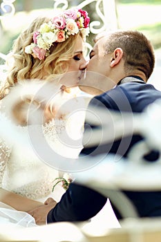 Handsome groom kissing blonde beautiful bride in magical fairy t