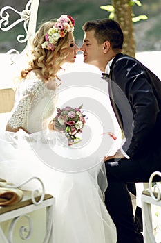 Handsome groom kissing blonde beautiful bride in magical fairy t