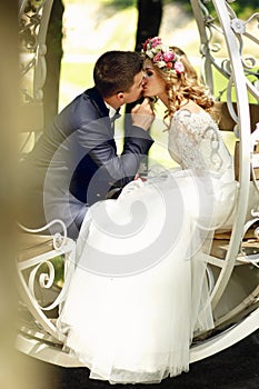 Handsome groom kissing blonde beautiful bride in magical fairy t