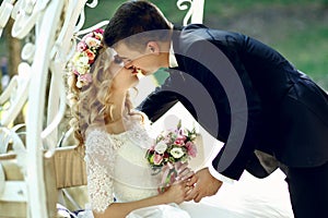 Handsome groom kissing blonde beautiful bride in magical fairy t