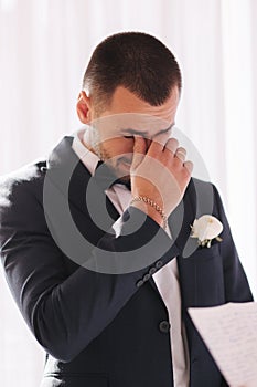 Handsome groom reading wedding vows and started crying. Groom have feeling of overwhelming love for bride