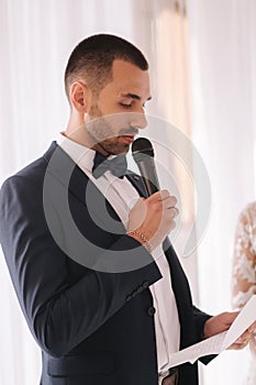 Handsome groom reading wedding vows and started crying. Groom have feeling of overwhelming love for bride