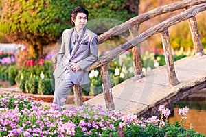 Handsome Groom Stand and Leaning at Wood Bridge in Park