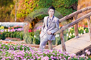 Handsome Groom Stand and Leaning at Wood Bridge in Park