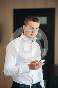 Handsome groom use phone in wedding day