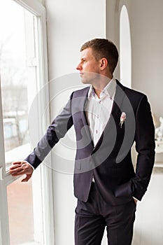 Handsome groom is wearing fashion costume.