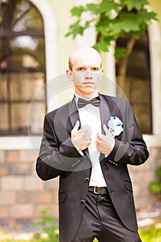 Handsome groom at wedding tuxedo smiling and