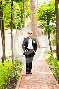 Handsome groom at wedding tuxedo smiling and