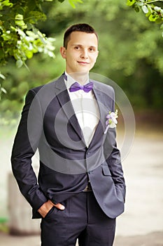 Handsome groom at wedding tuxedo smiling and waiting for bride