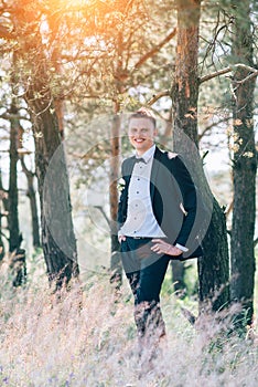 Handsome groom at wedding tuxedo smiling and waiting for bride.