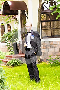Handsome groom at wedding tuxedo smiling and