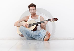 Handsome guitar player practicing